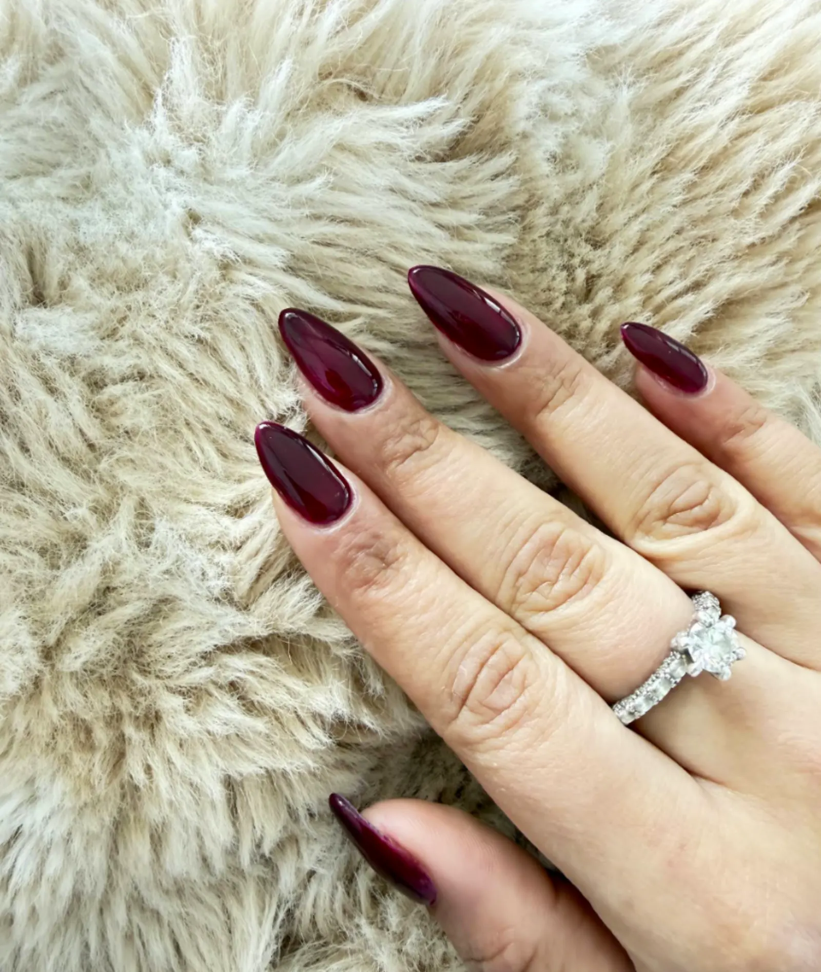 Deep wine red almond nails on sheepskin