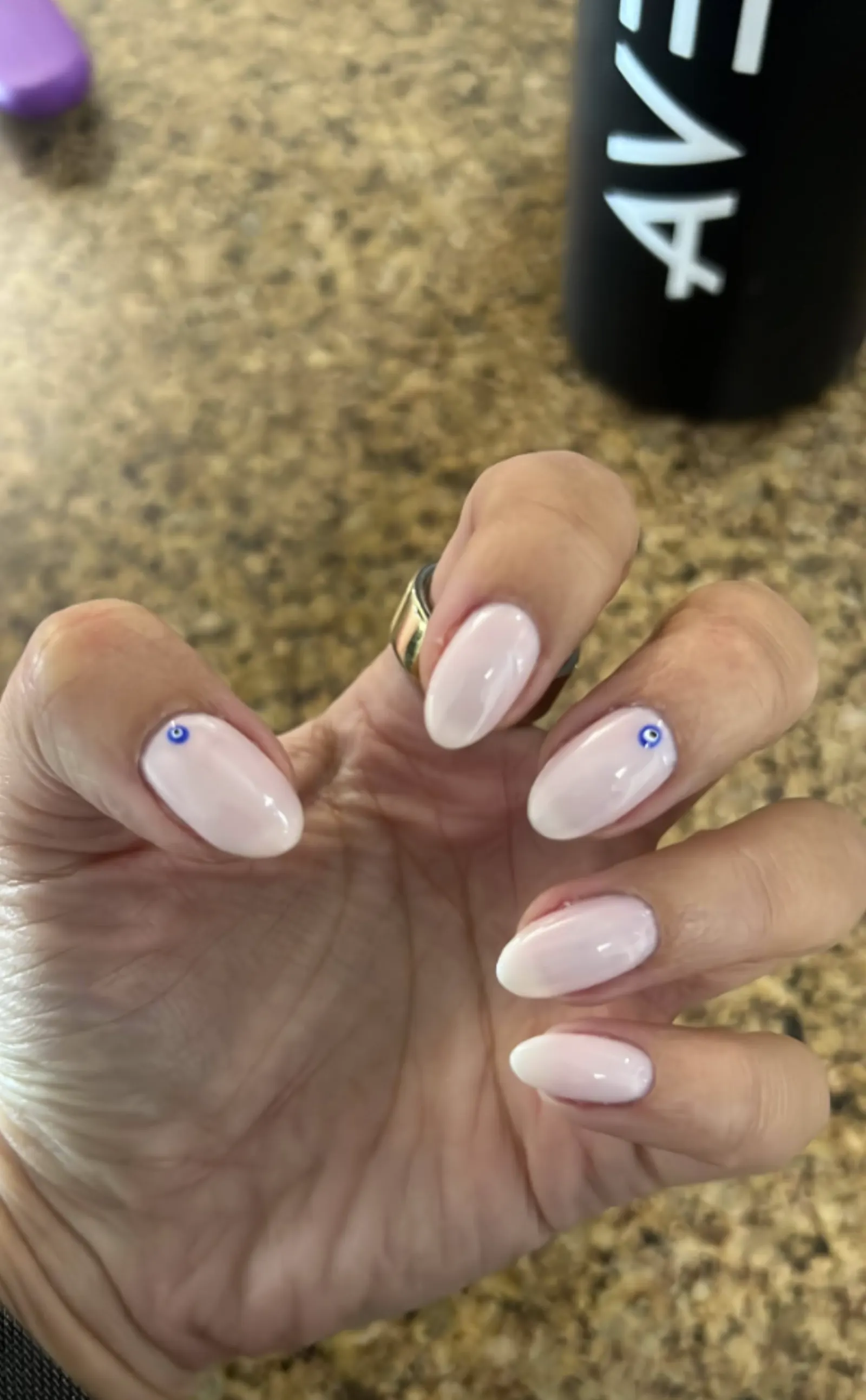 Milky white nails with tiny evil-eye accent